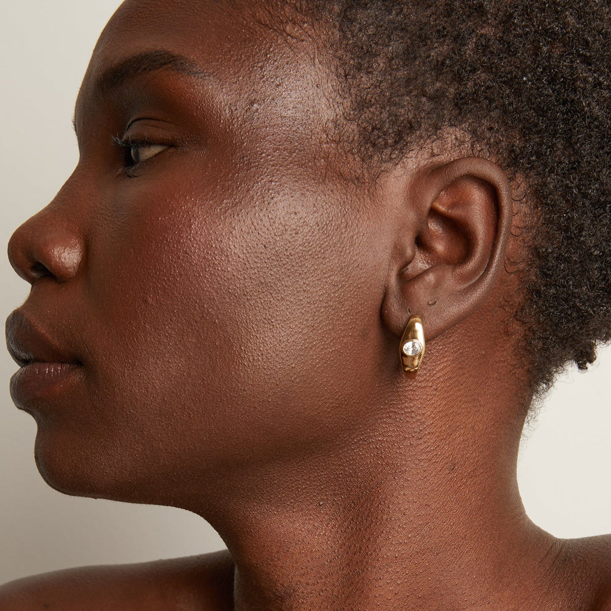 Model. Woman wearing gold earring 