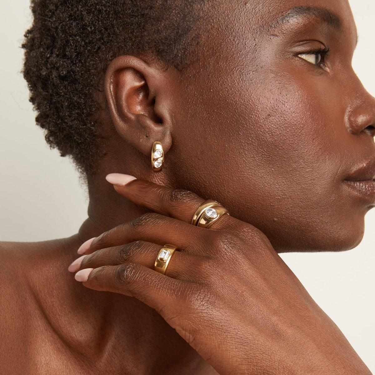 Model. Woman wearing gold earring and rings