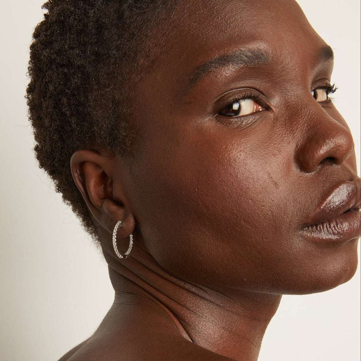 Model. Woman wearing diamond hoop earrings