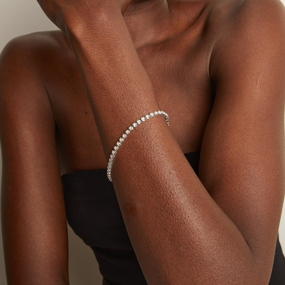 Model. Silver bracelet on a person's wrist with a neutral background