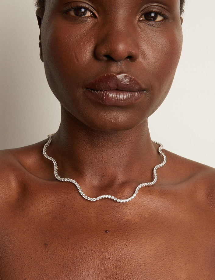 Model.  close up of woman wearing wavy necklace 