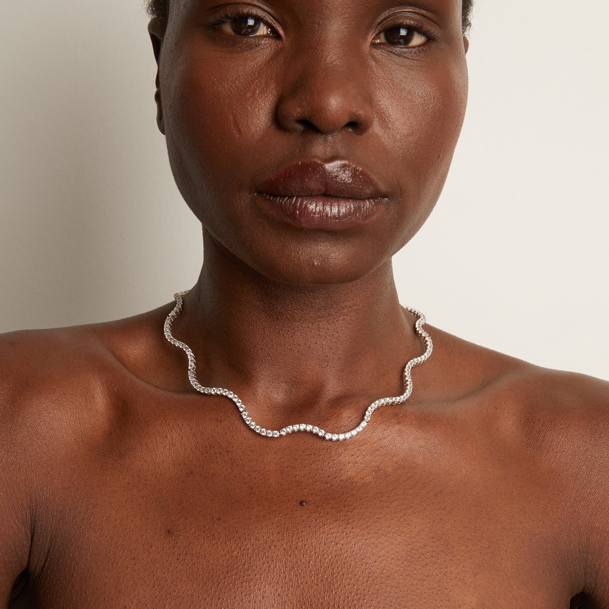 Model.  close up of woman wearing wavy necklace 