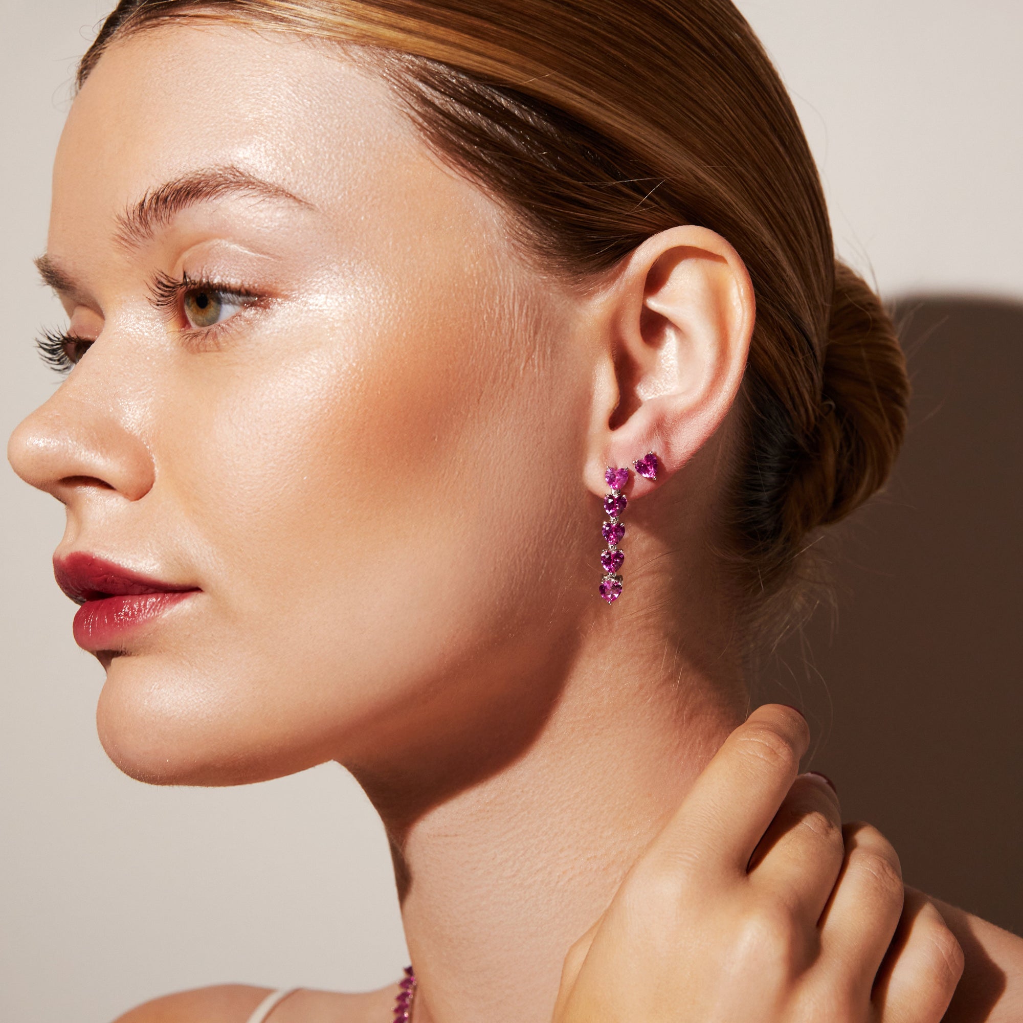 Model.  Close up of woman wearing pink earrings 