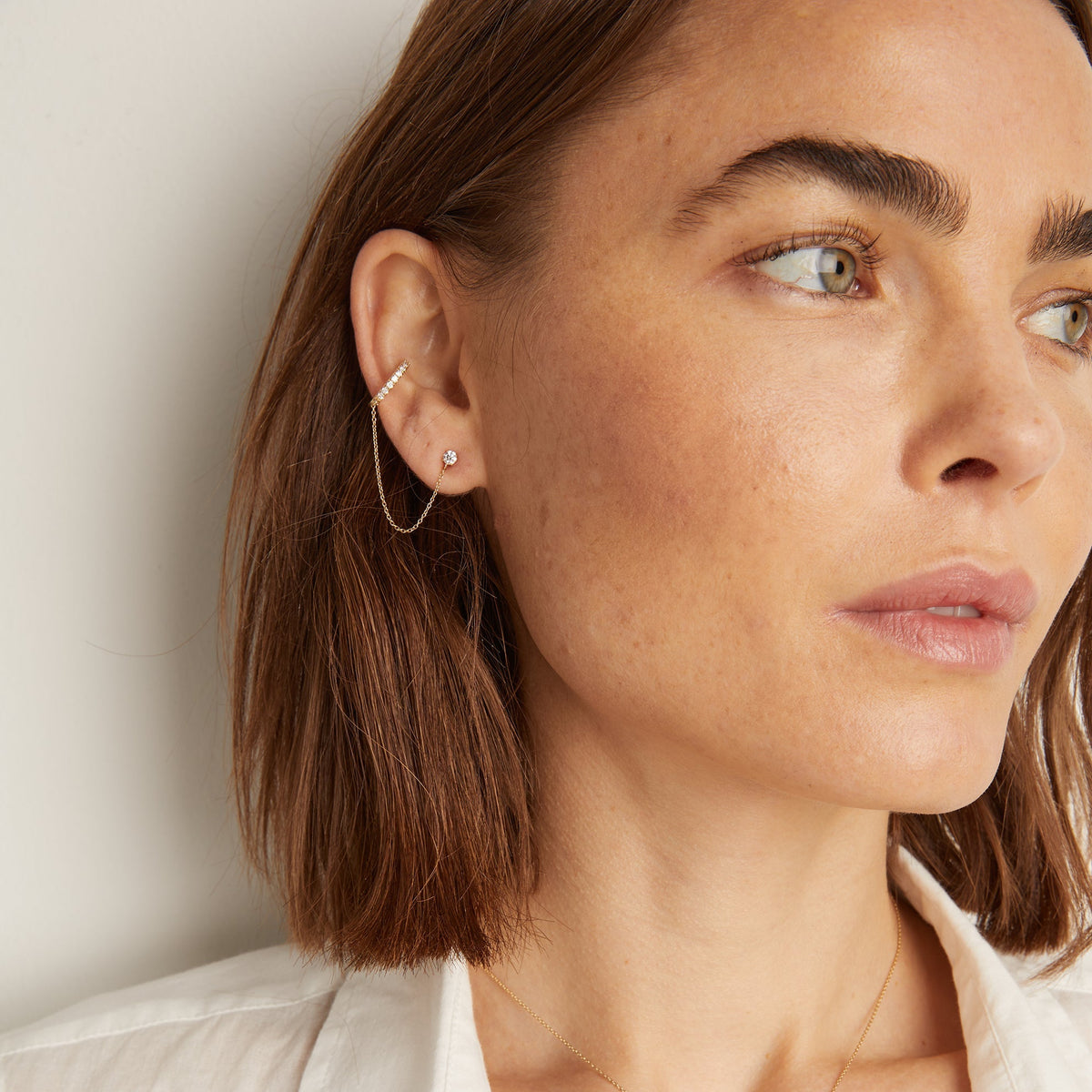 Model. Woman wearing diamond cuff and stud chain earring