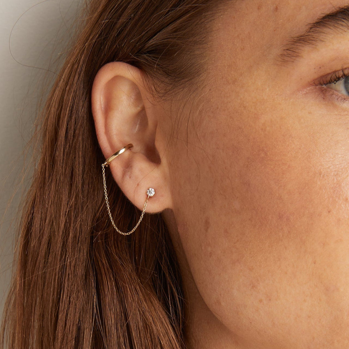 Model. Woman wearing diamond cuff and stud chain earring