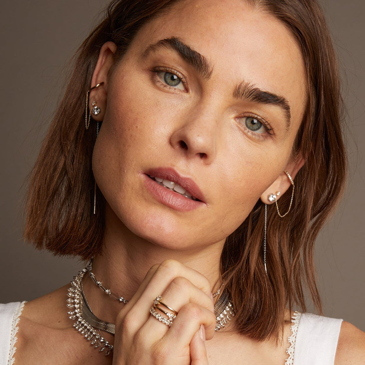 Model. Woman wearing various jewelry on beige background