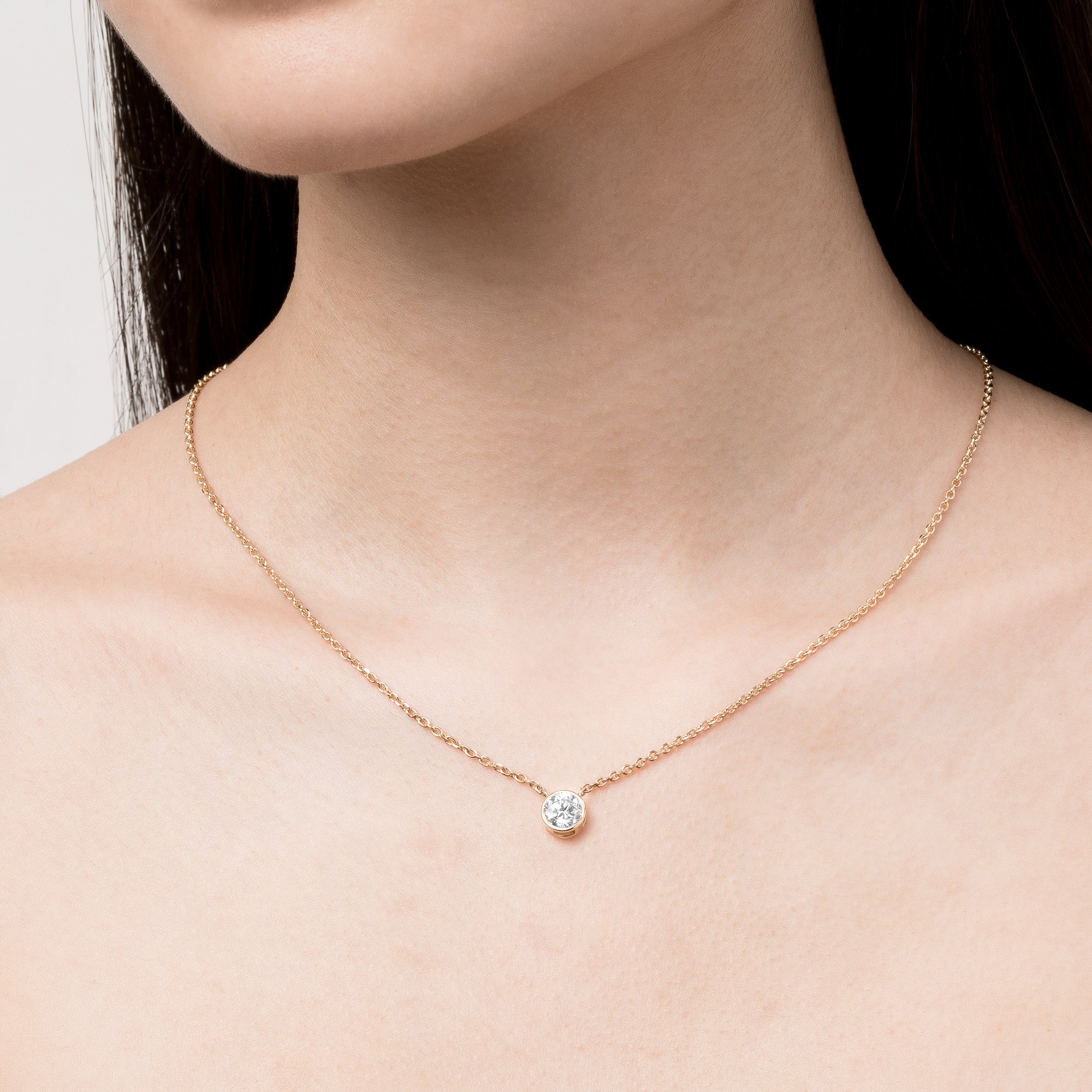 Model. Close up of a woman's neck with a diamond pendant necklace