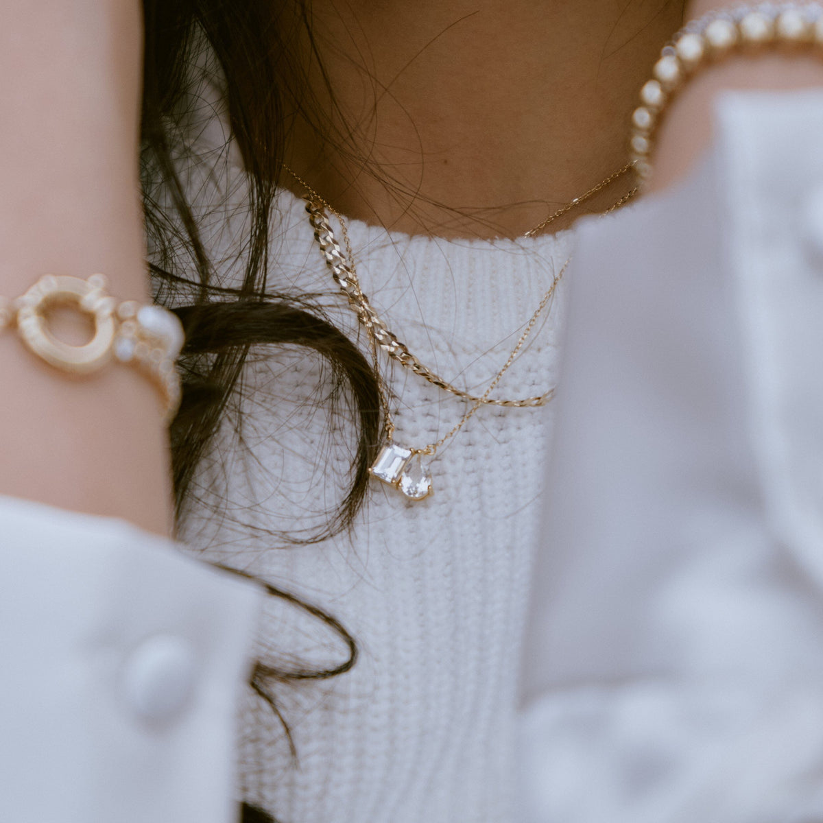 Lifestyle Model. Close of up woman wearing stacked necklaces.