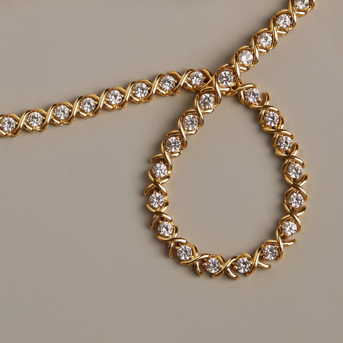 Flatlay Model. Gold bracelet with diamond accents on a beige background