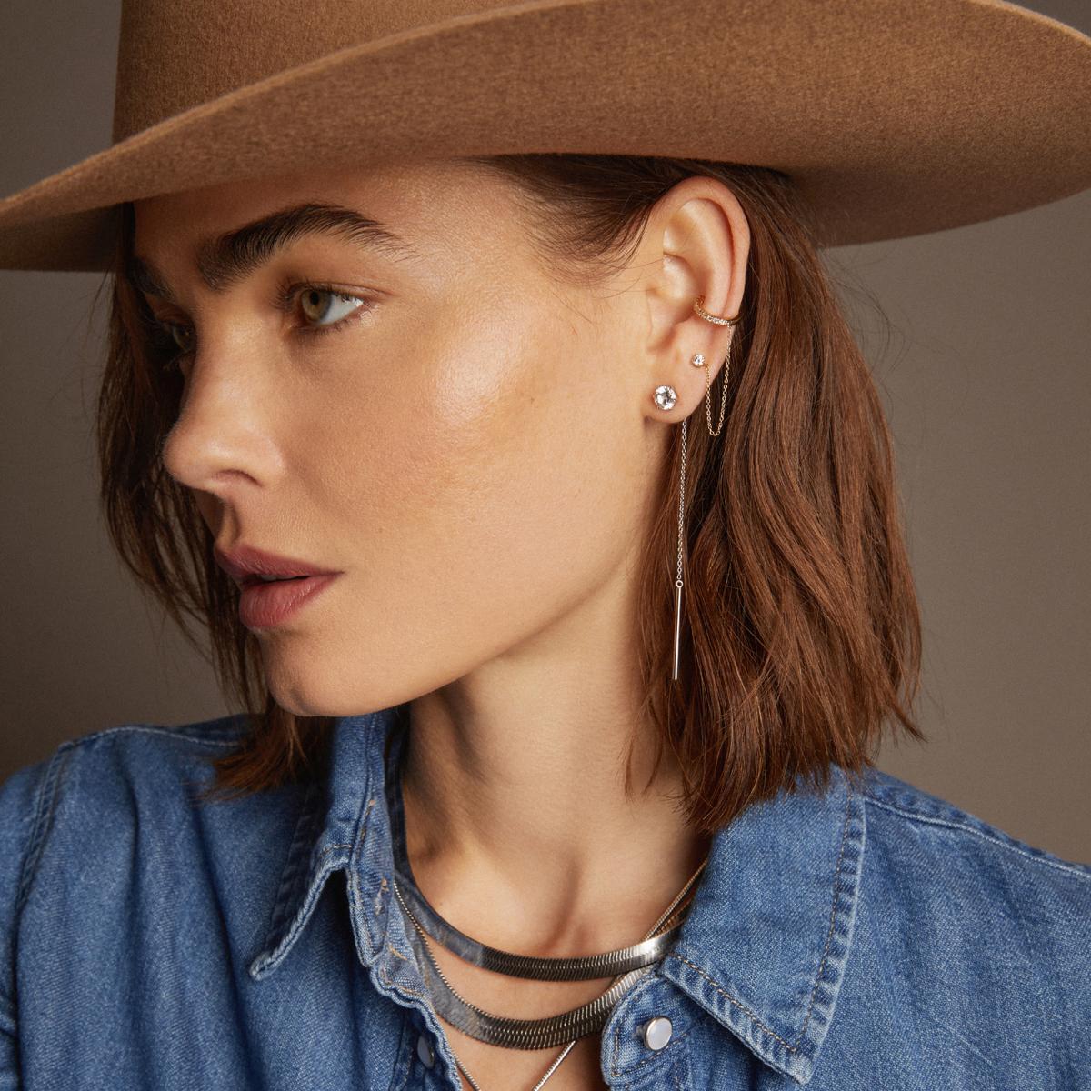 Model. Woman wearing various jewelry on beige background