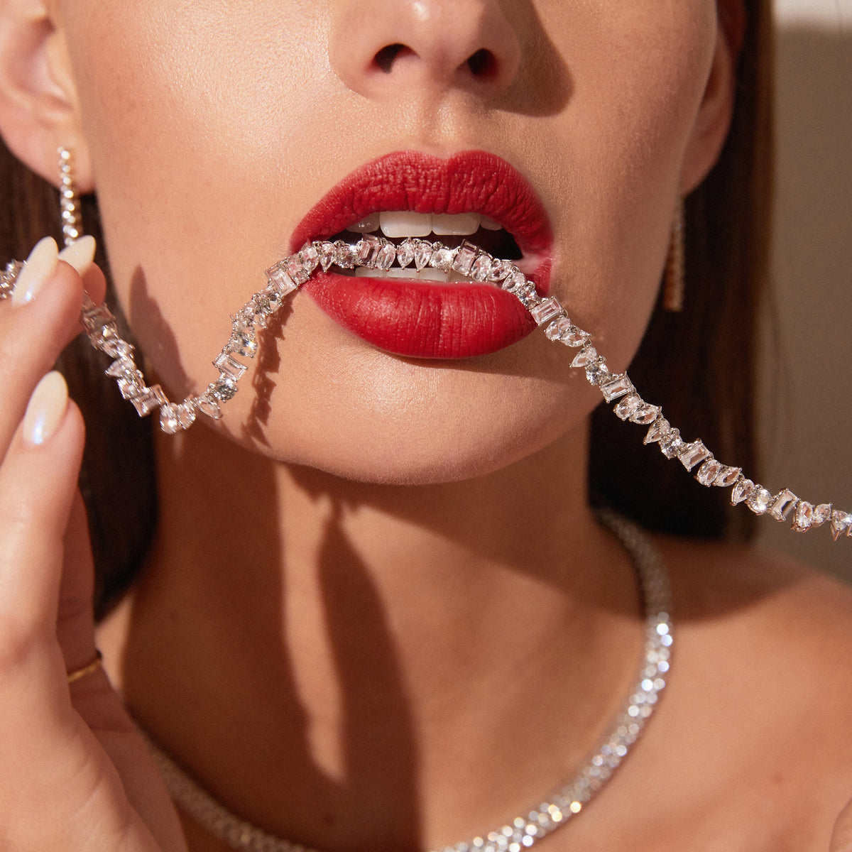 Model. Close up of woman with a tennis necklace with unique shape in her mouth