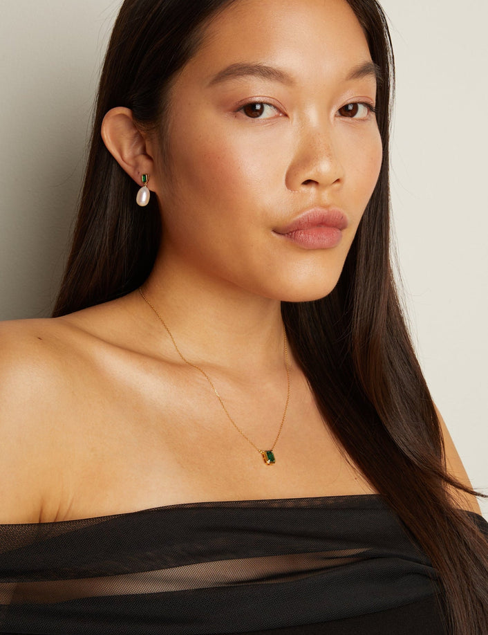 Model. Woman wearing a black off-shoulder top with a plain background
