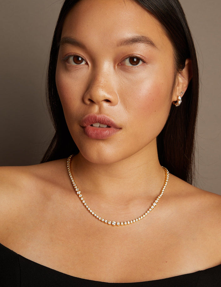 Model. Woman wearing a pearl necklace against a neutral background