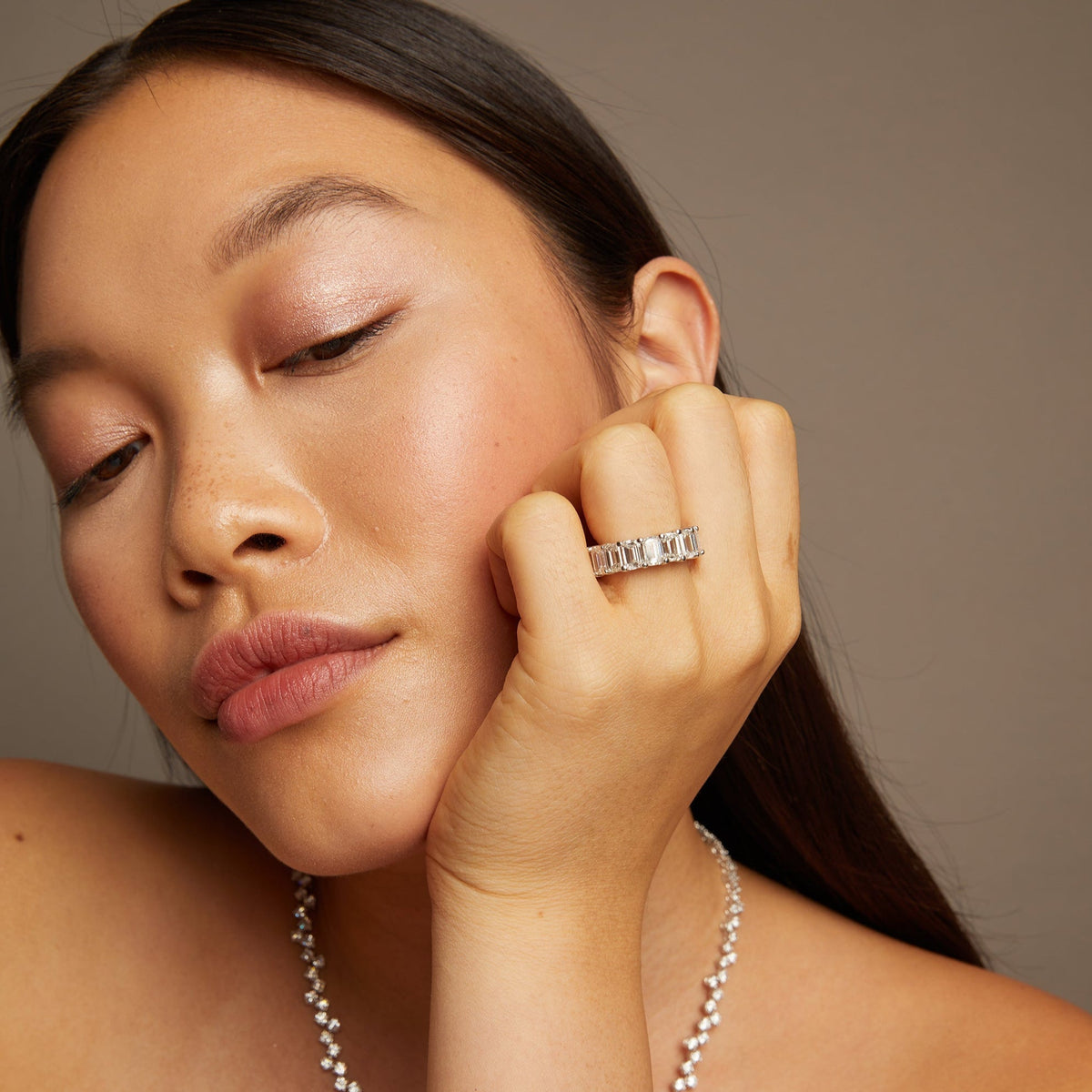 Model. Woman wearing a silver ring and bracelet against a neutral background