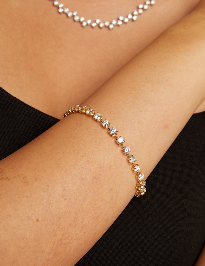 Gold bracelet with clear stones on a person
