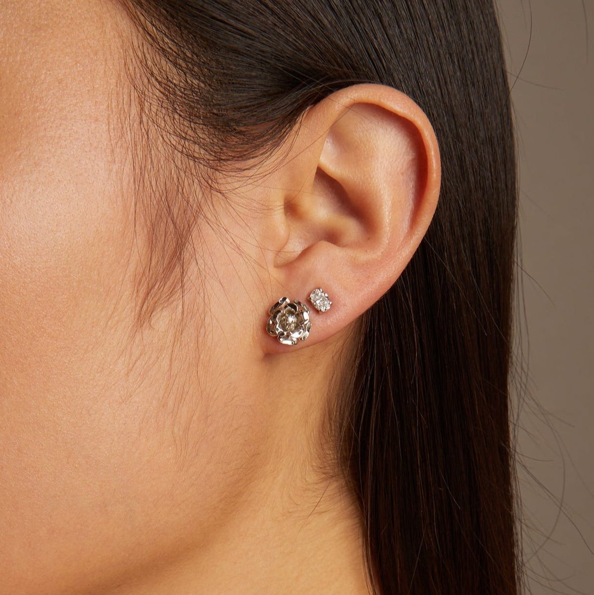 Model. Close-up of a woman wearing earrings with a neutral background