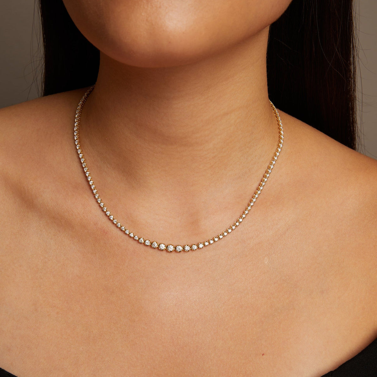 Model. Close-up of a person wearing a delicate silver necklace.