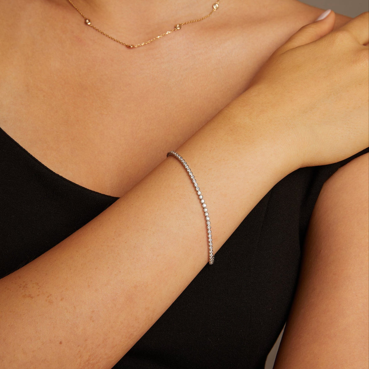 Model. Close-up of a person wearing a delicate bracelet on their wrist.