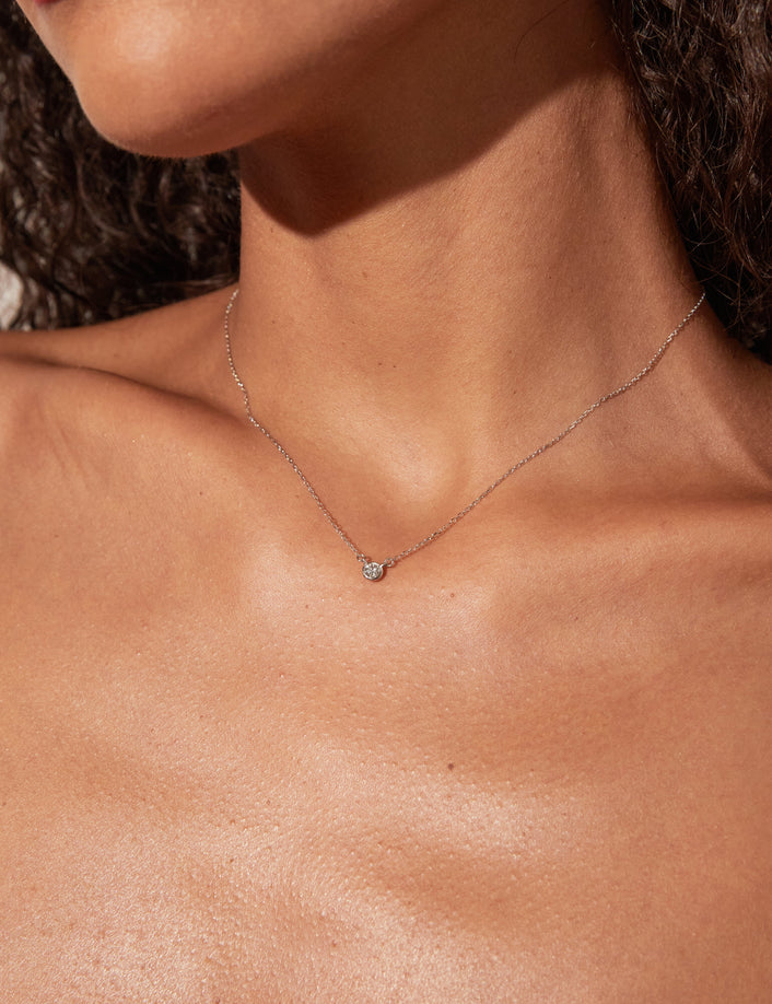 Woman wearing necklace with small stone 