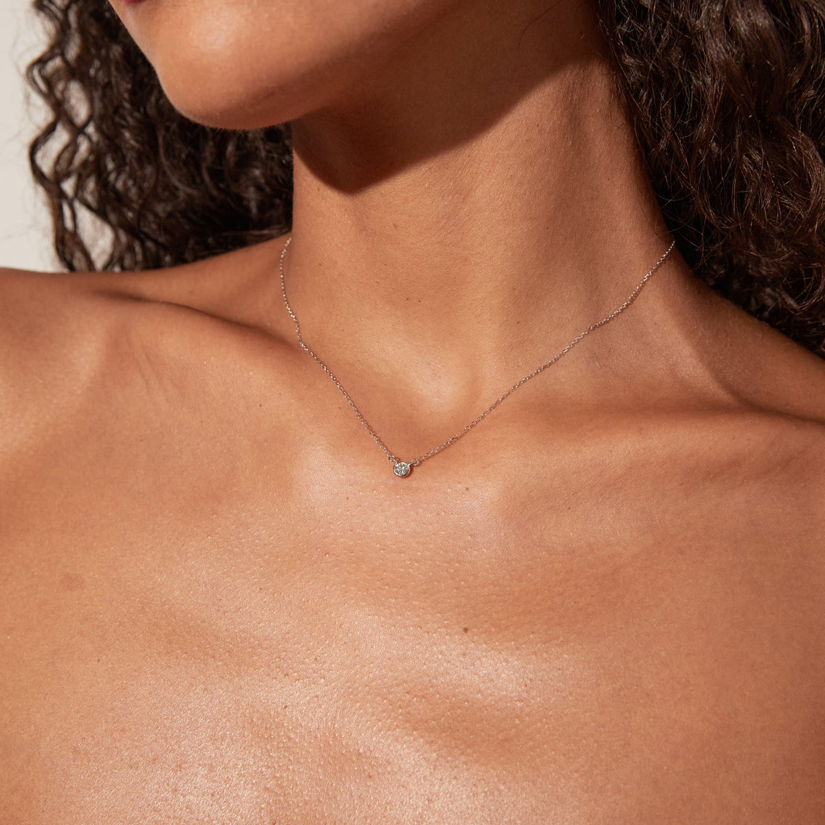 Woman wearing necklace with small stone 