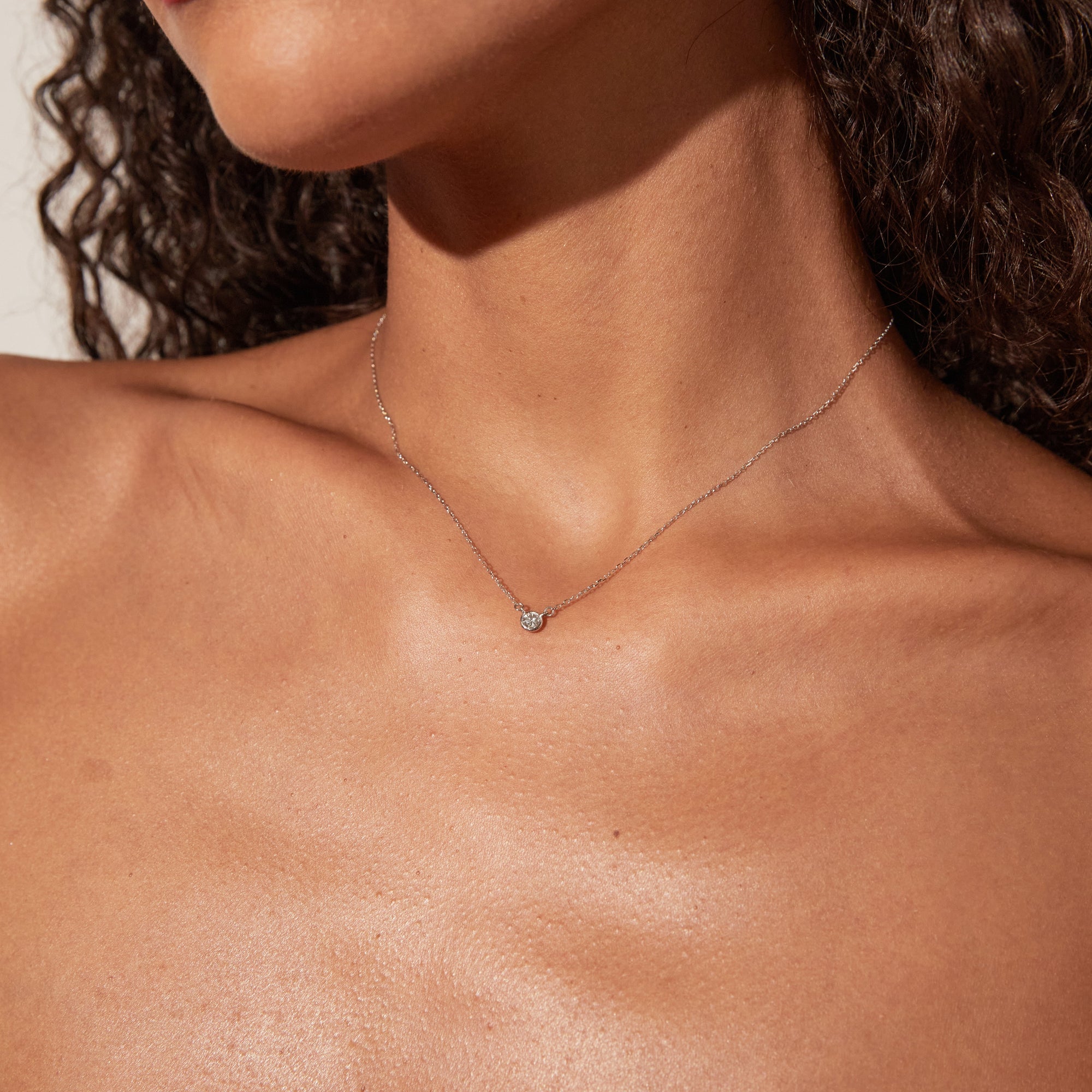 Woman wearing necklace with small stone 