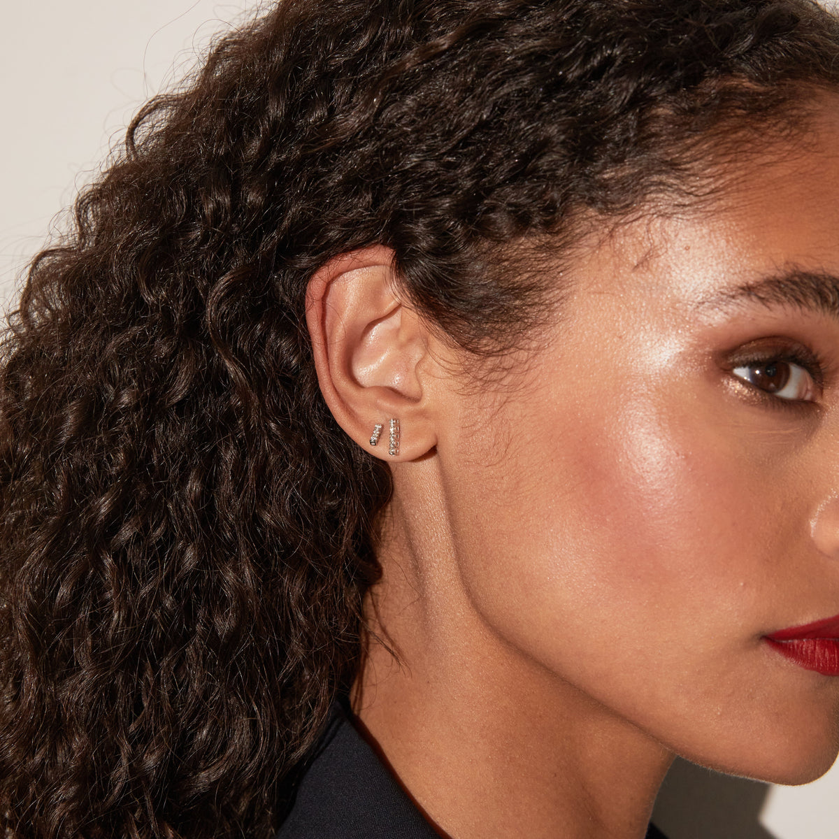 Model.  close up of woman wearing bar earrings 