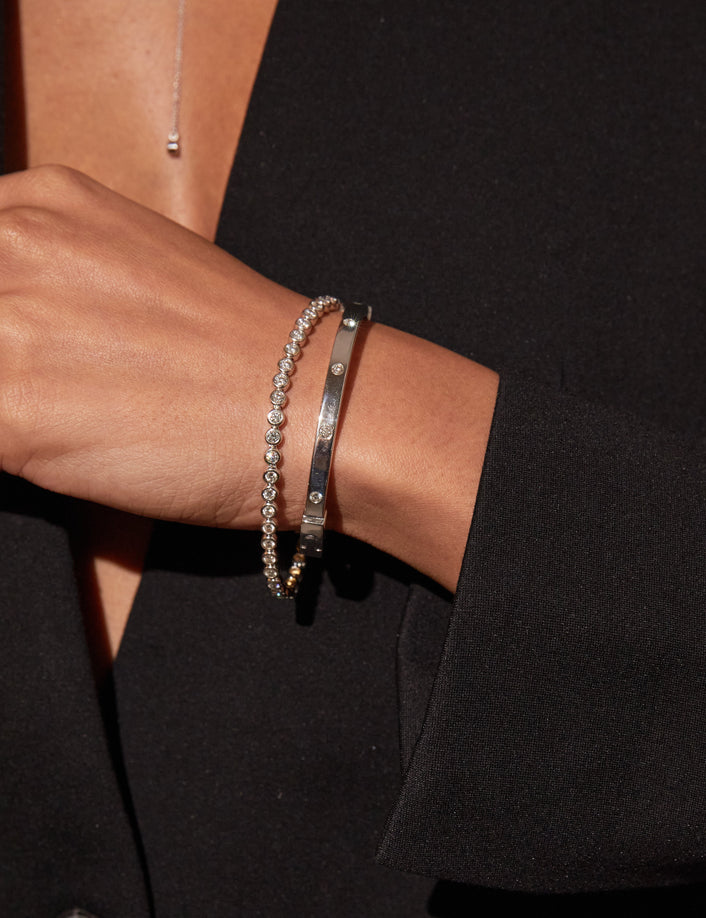 Model. Close up on woman wearing two bracelets with black blazer