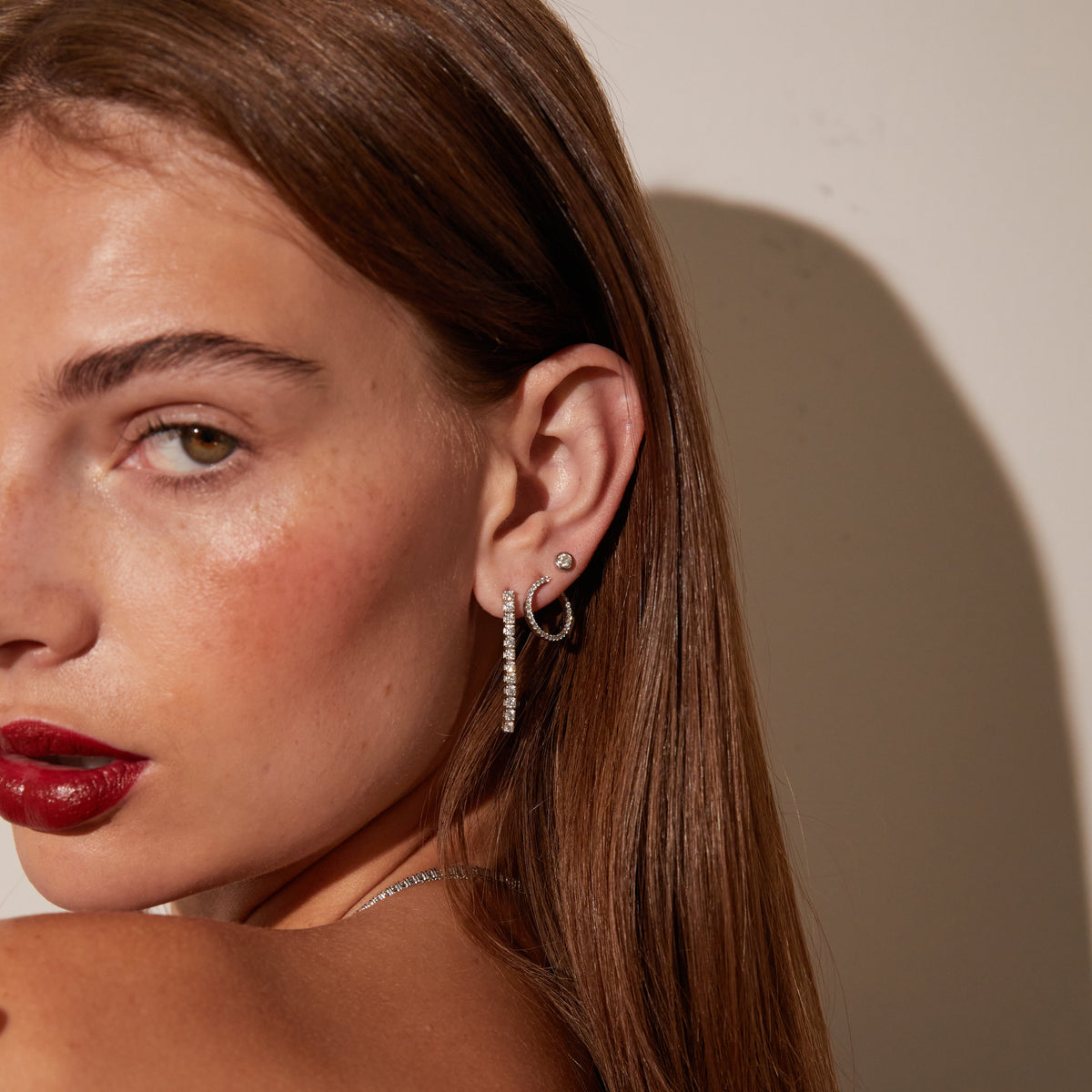 Model.  side profile of woman wearing diamond earrings 
