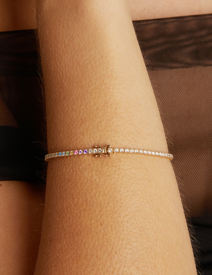 Close-up of a wrist wearing a colorful bracelet against a brown background