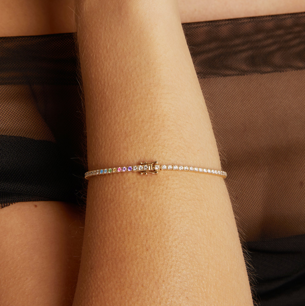 Close-up of a wrist wearing a colorful bracelet against a brown background