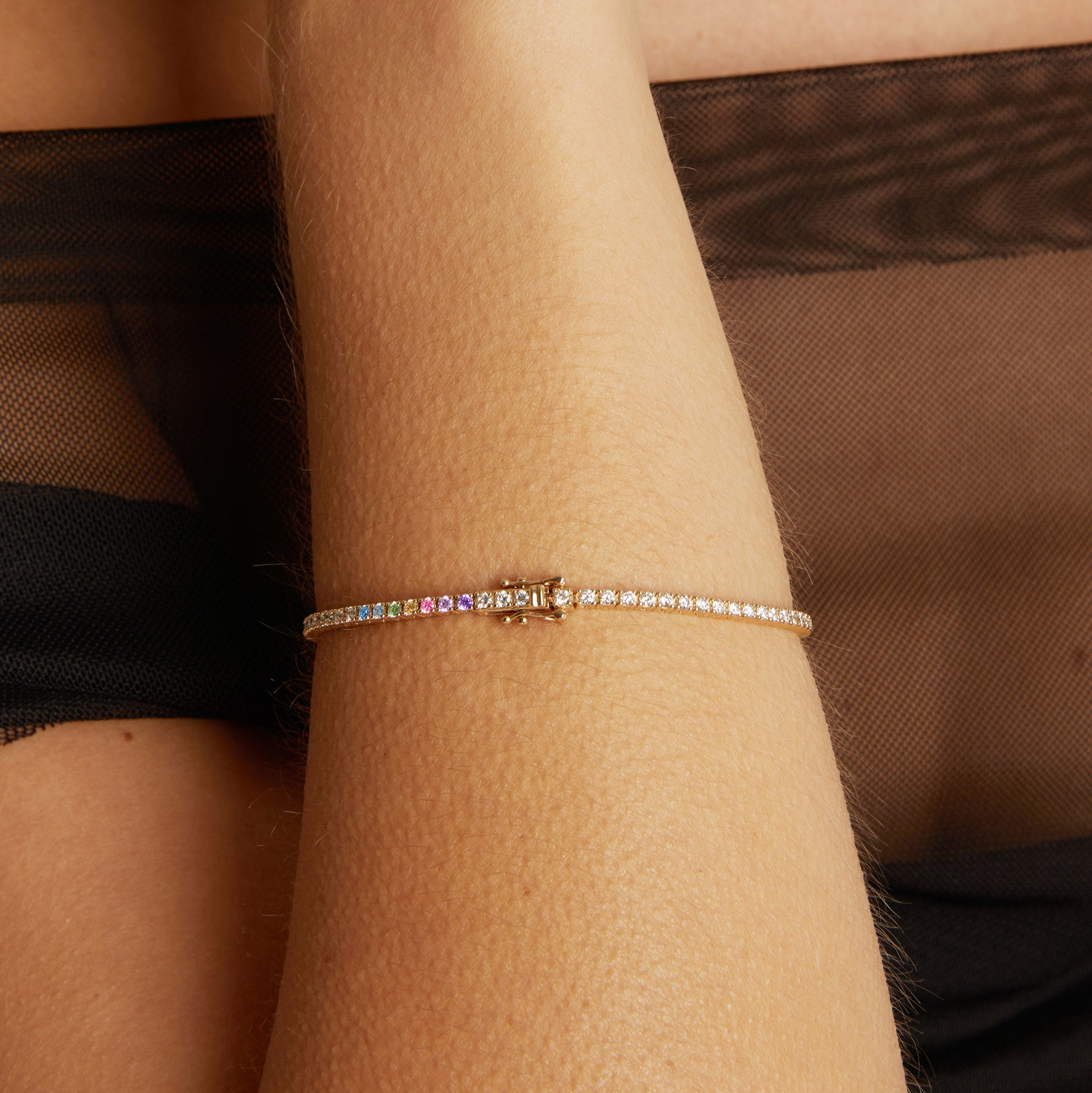 Close-up of a wrist wearing a colorful bracelet against a brown background