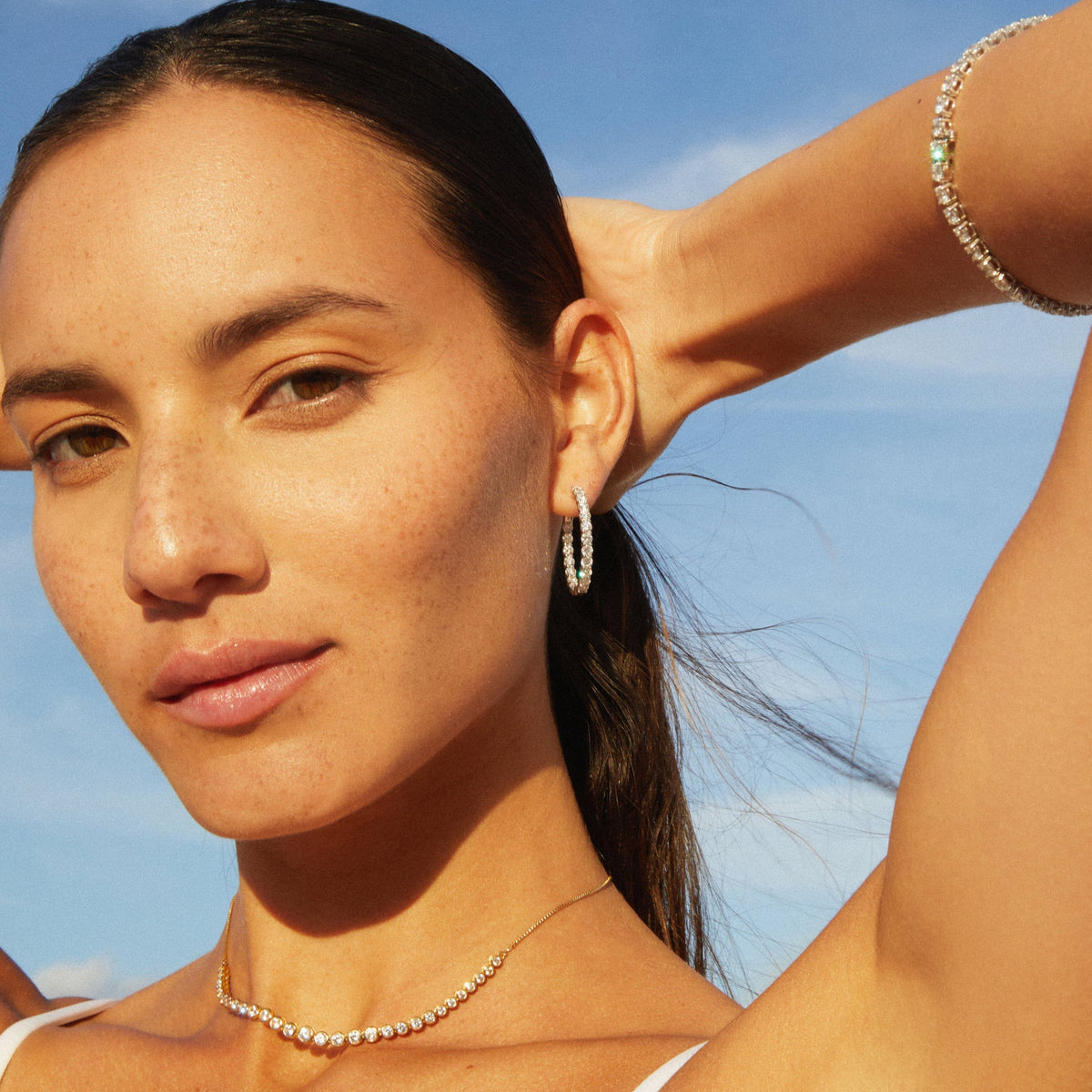 Model.  woman wearing diamond bracelet and hoop earring 