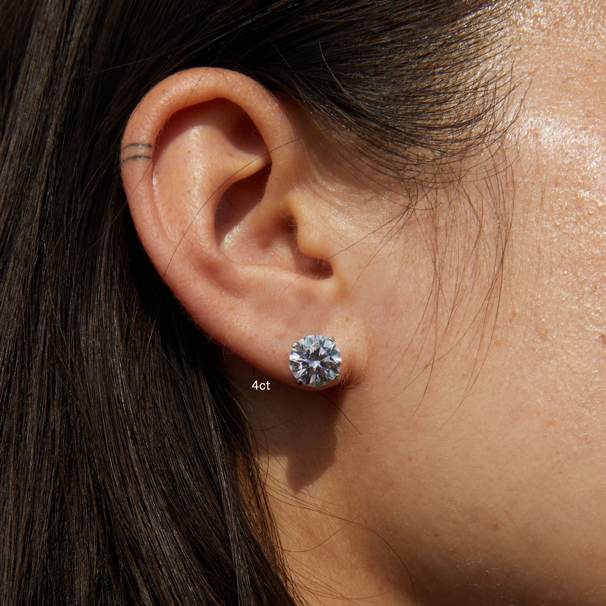 Model.  side profile of woman wearing diamond stud 