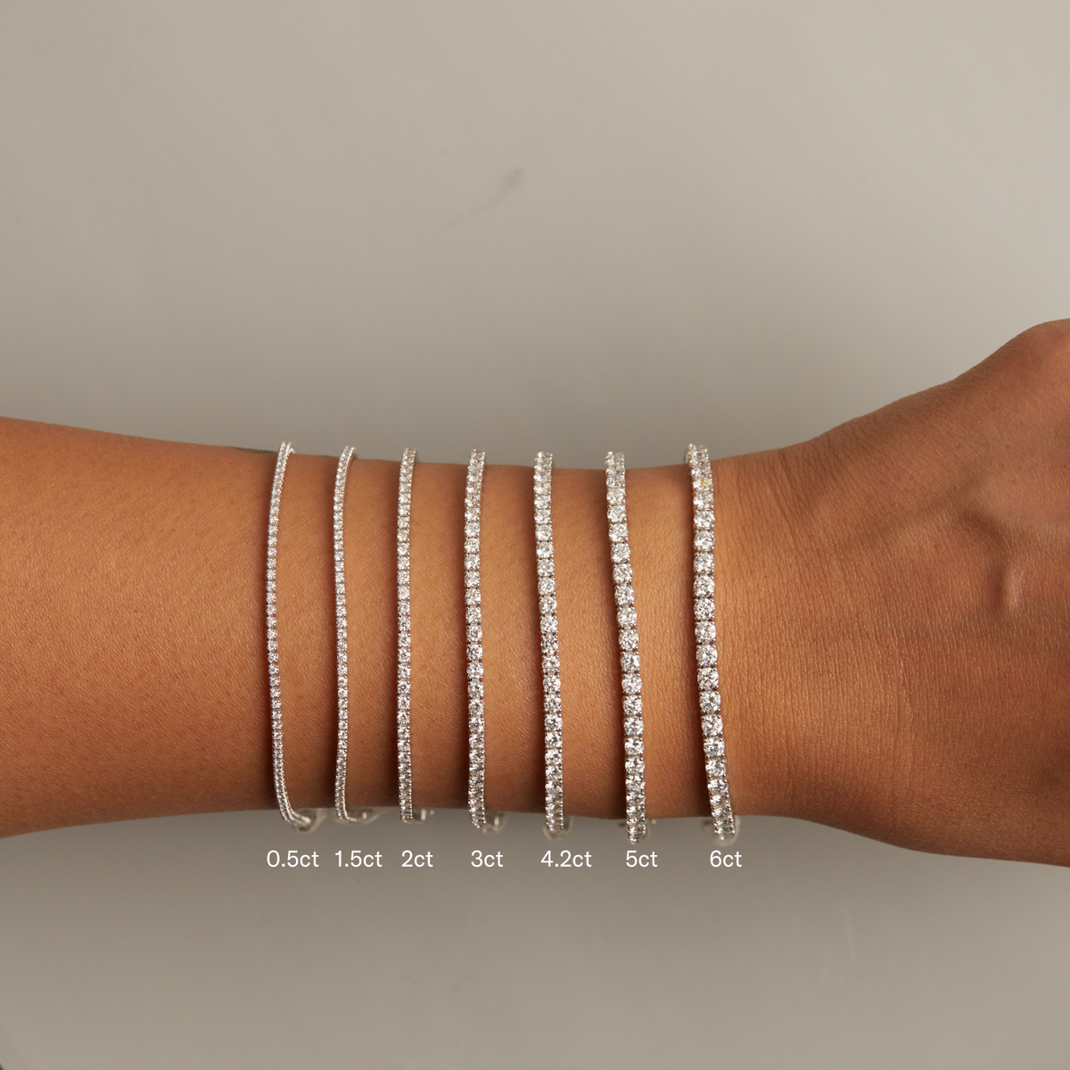 Model. Set of diamond bracelets on a wrist with weight labels.