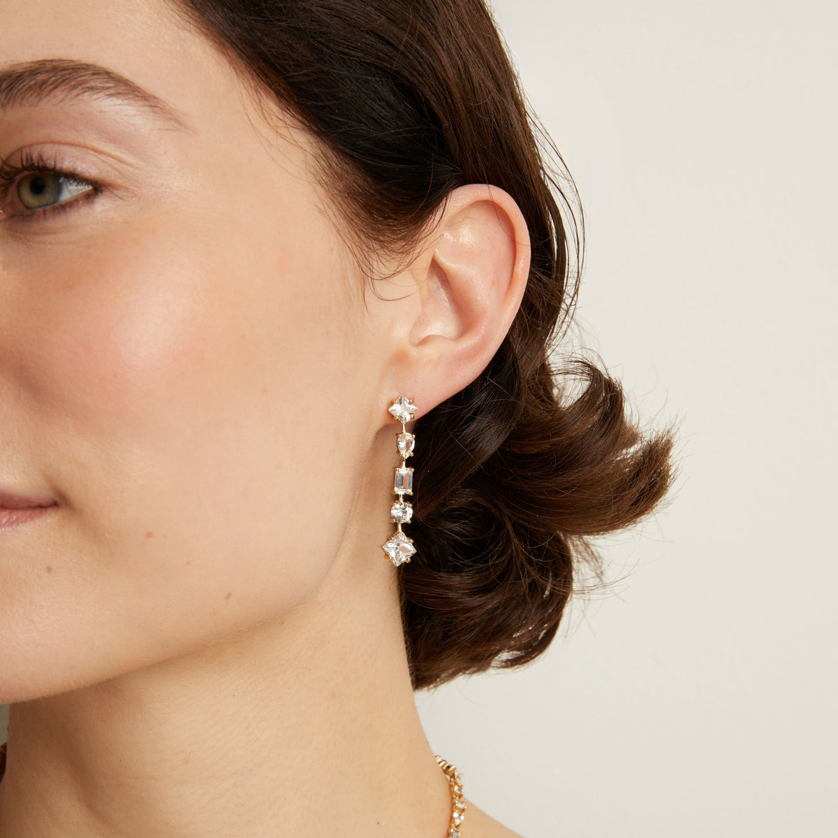 Model. Mixed shape tennis earrings on woman with neutral background.