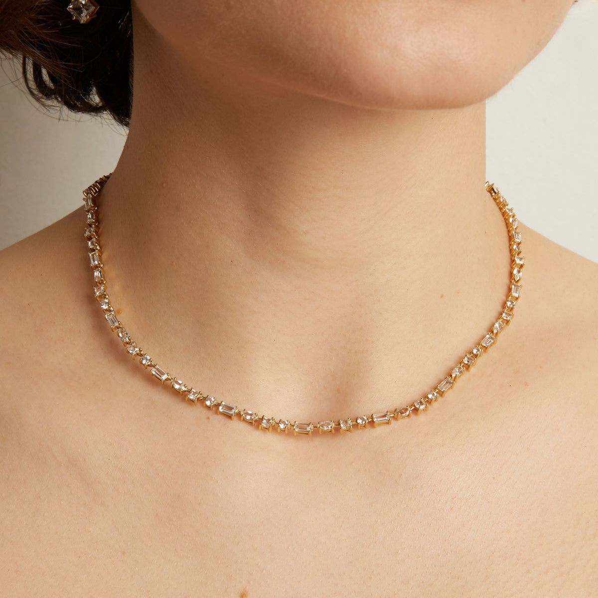Model. Mixed shape tennis necklace on a person's neck against a neutral background