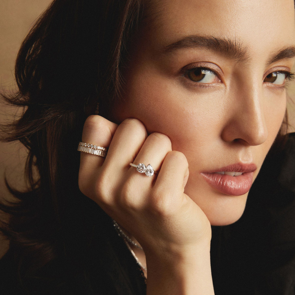 Model. Close-up of a woman wearing diamond rings with a neutral background
