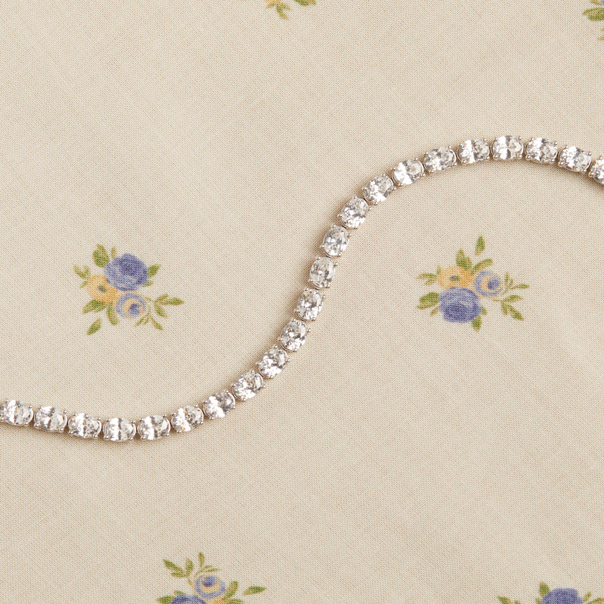 Model. Diamond bracelet on a floral-patterned fabric background
