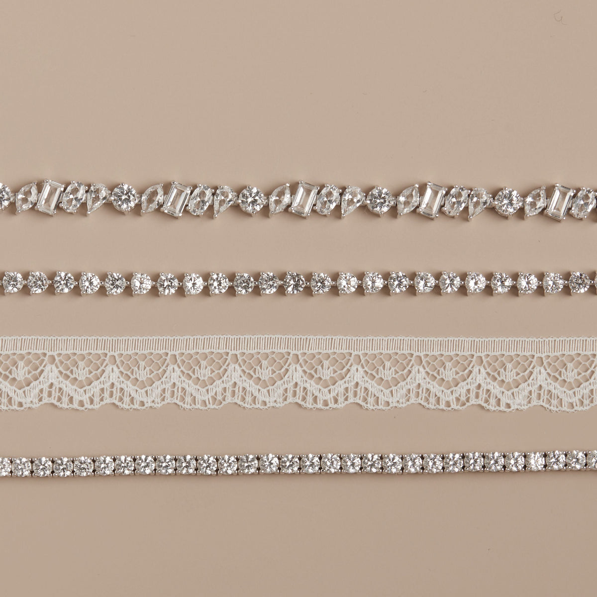 Model. Set of decorative ribbons with crystals and lace on a beige background