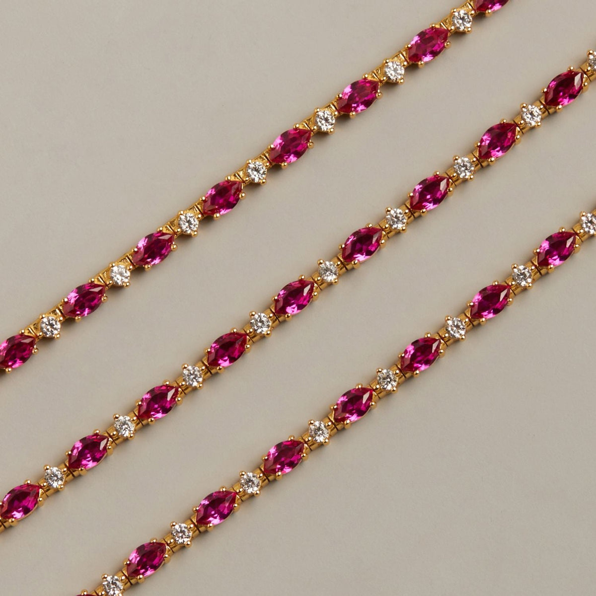 Model. Gold chain with pink gemstones on a beige background