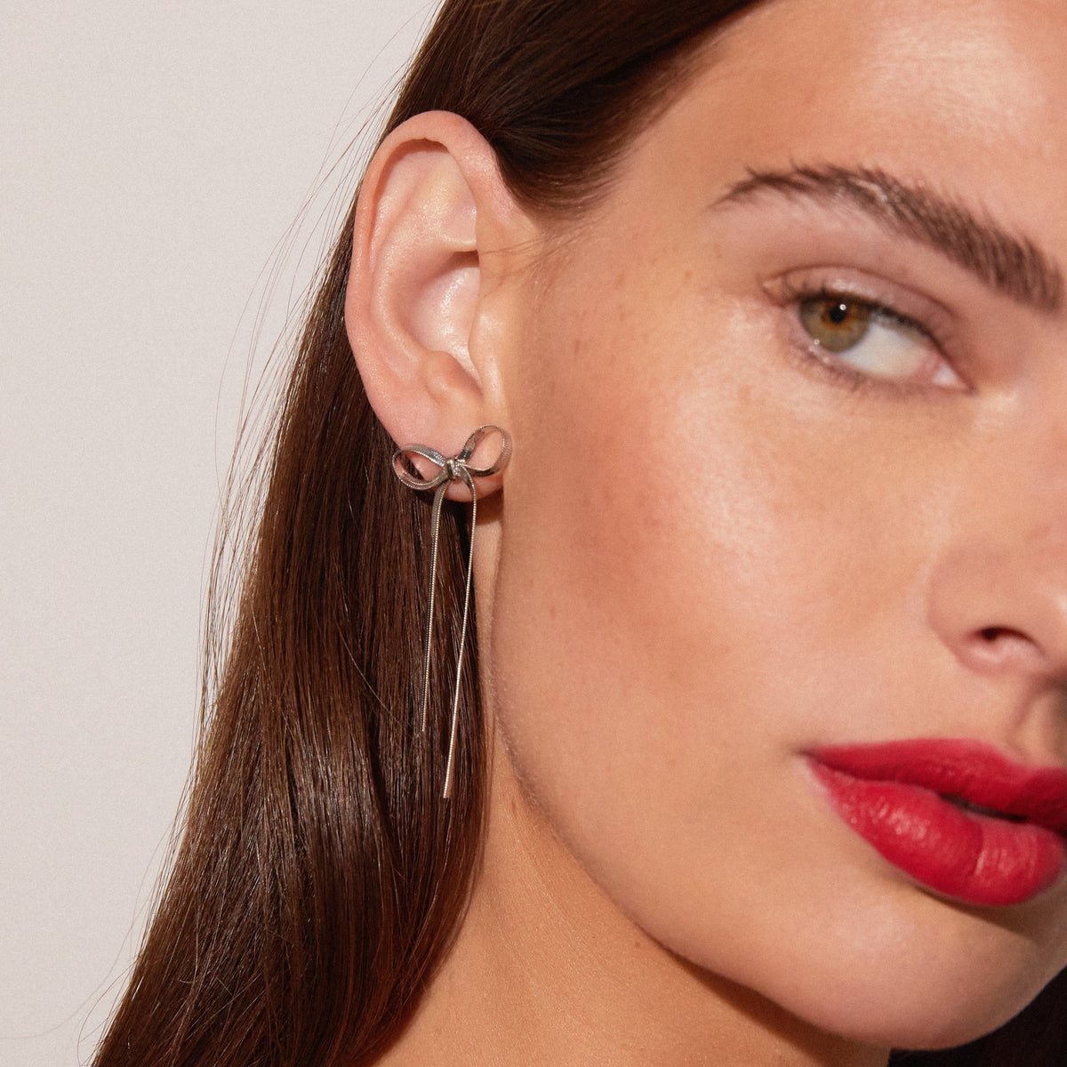 Model. Close up of woman wearing bow earring 