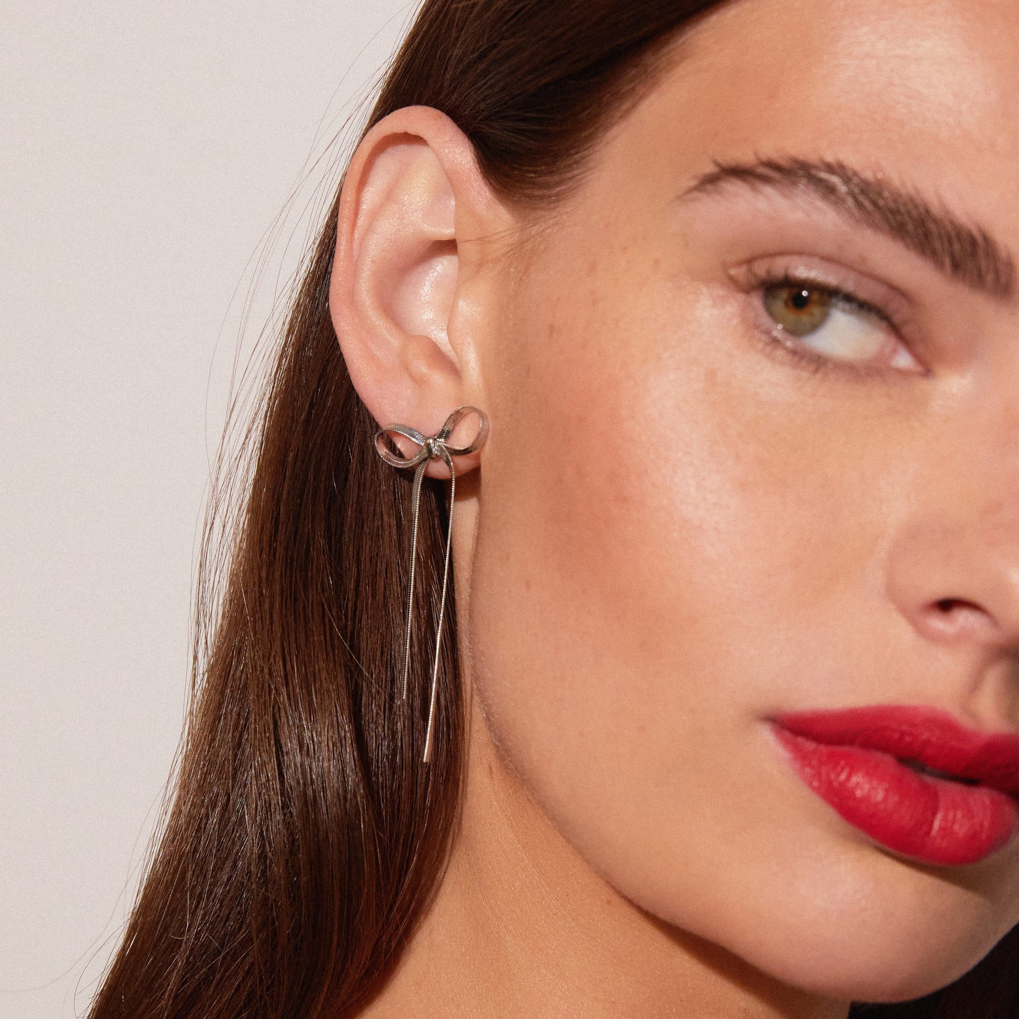Model. Close up of woman wearing bow earring 