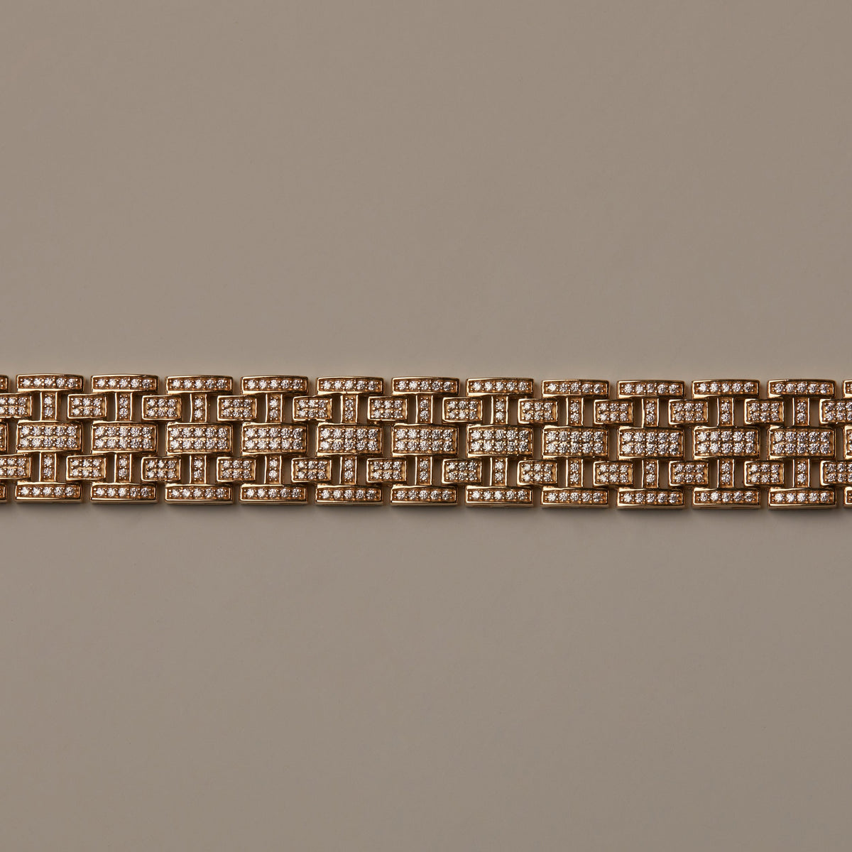 Flatlay Model. Gold bracelet with diamond accents on a beige background