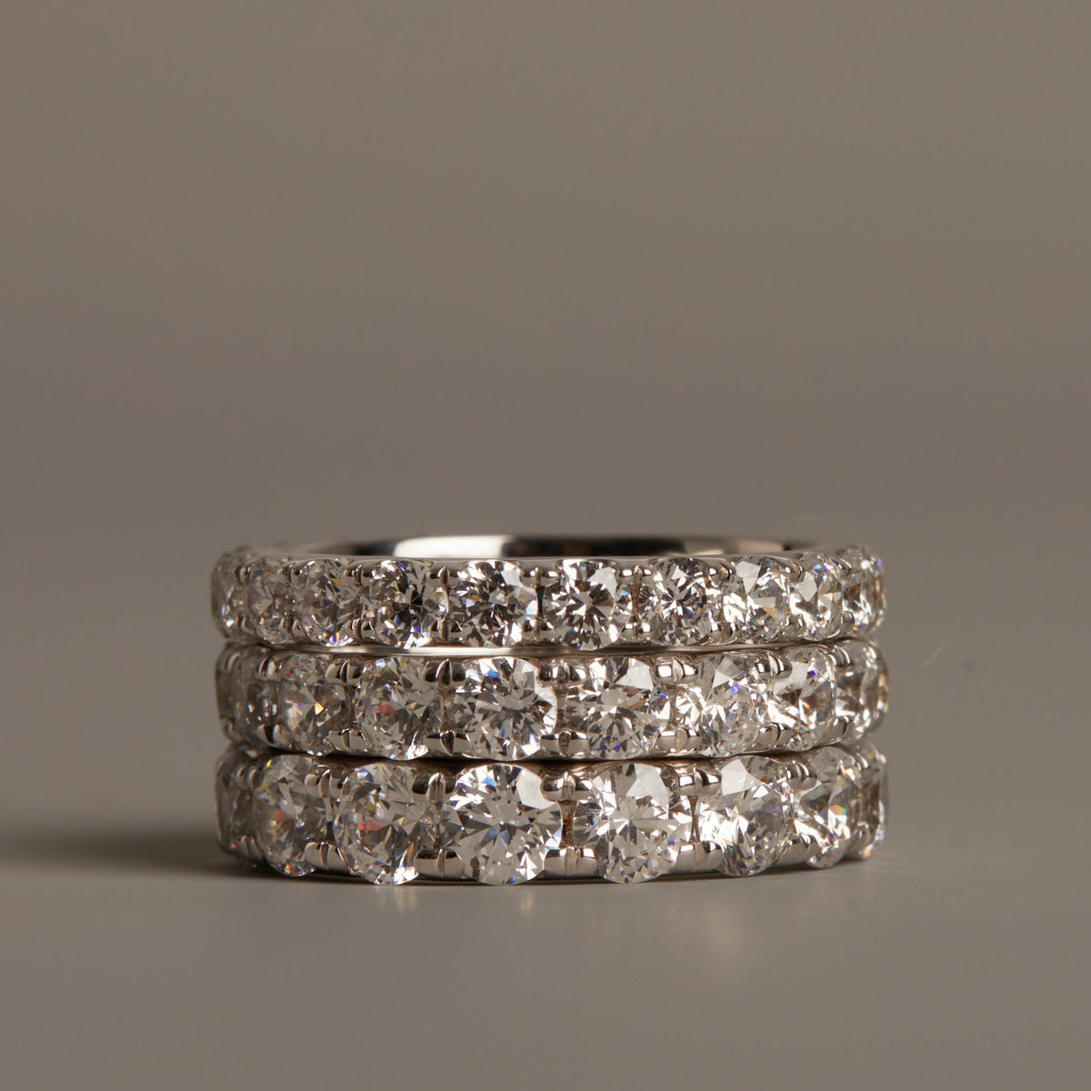 Flatlay Model. Three diamond-studded rings stacked on a gray background