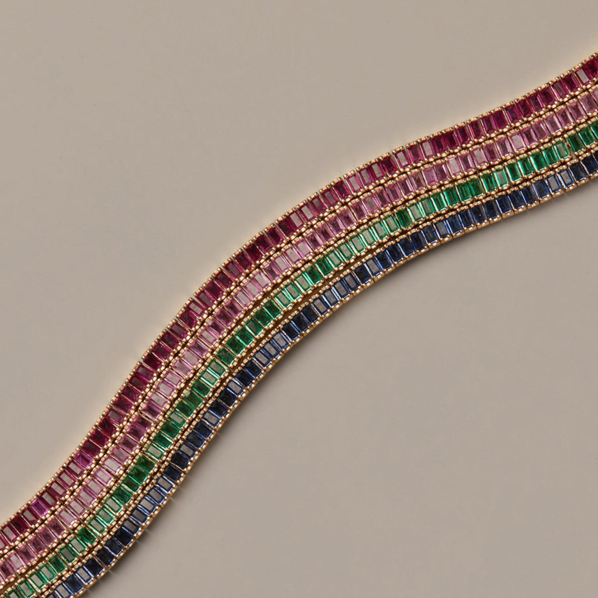Model. Jewelry with multicolored gemstones on a beige background