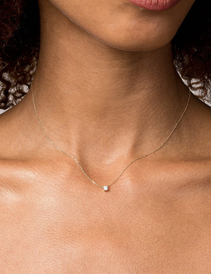 Model close up of woman wearing a diamond pendant necklace 