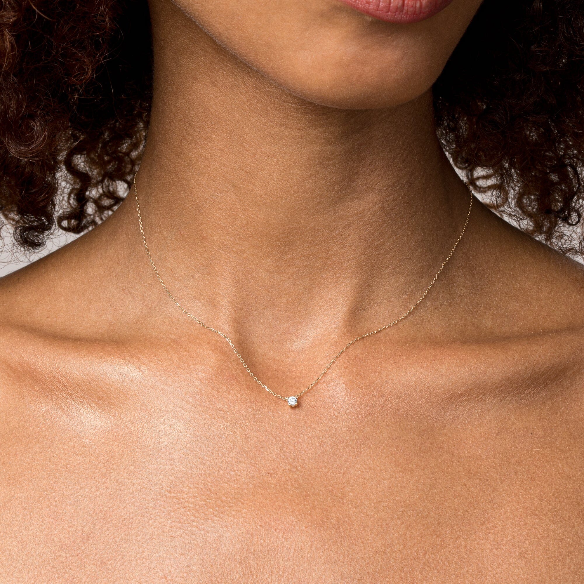 Model close up of woman wearing a diamond pendant necklace 