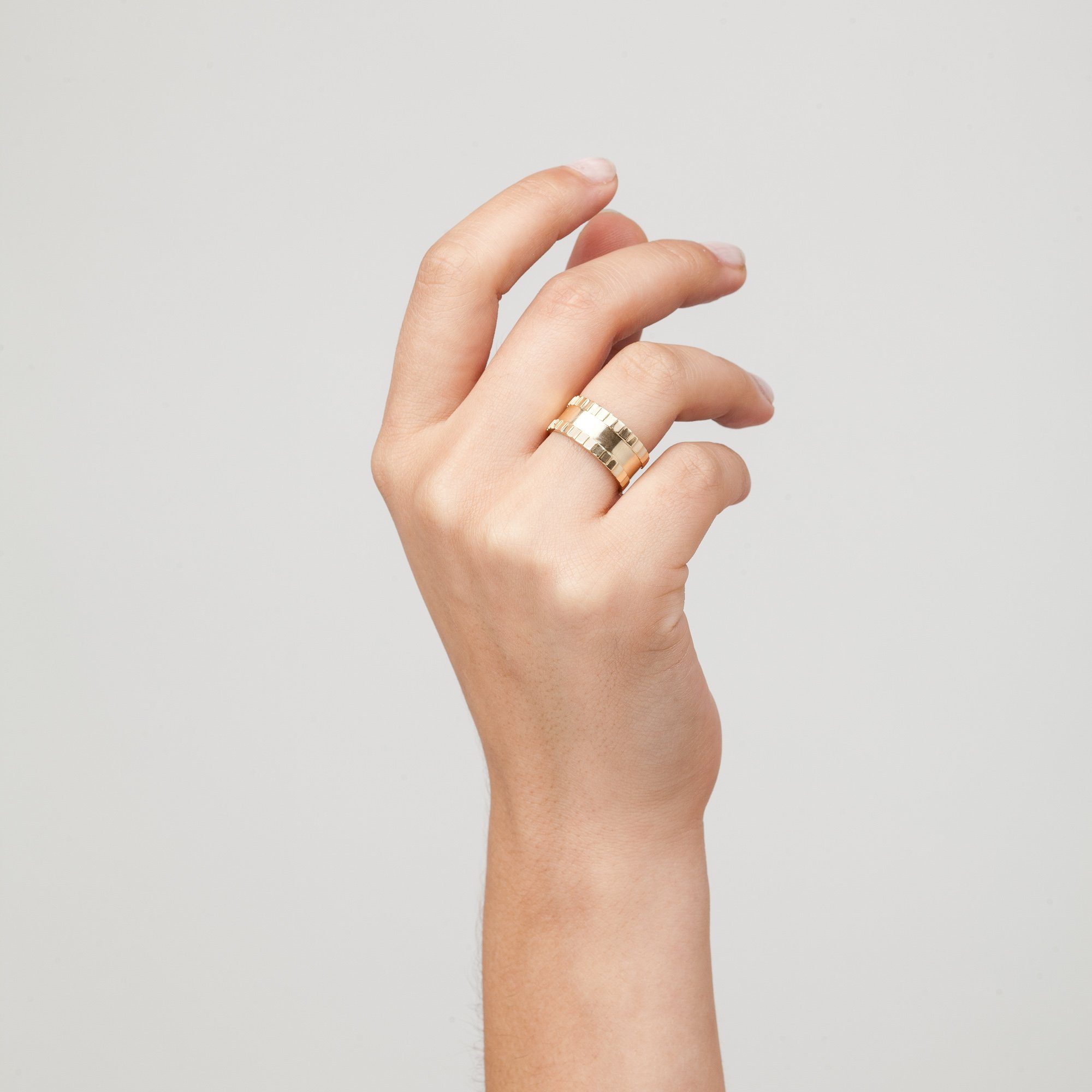 Model. Close up of woman's hand wearing gold ring