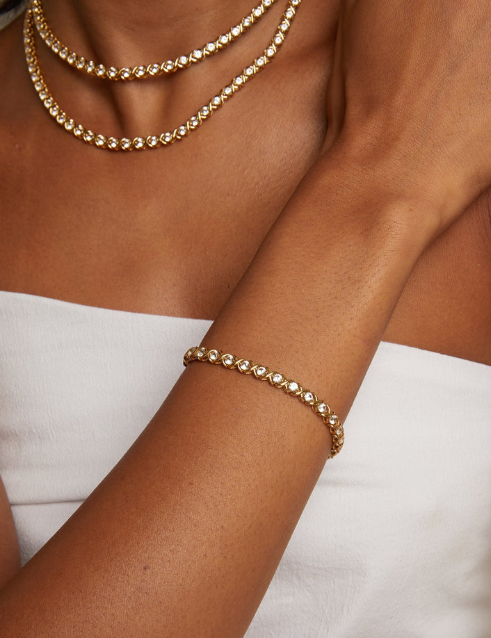 Model. Gold bracelet on a wrist with a neutral background