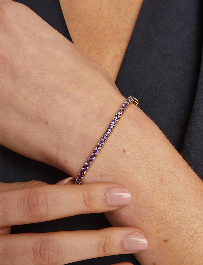 Close-up of a wrist wearing a beaded bracelet with a dark background